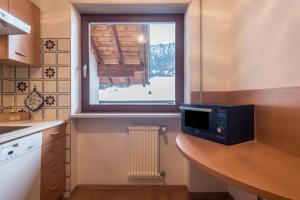 a kitchen with a microwave on a counter with a window at Casa Rustica App Saslonch in Ortisei