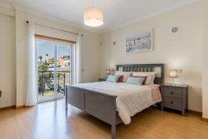 une chambre avec un lit et une grande fenêtre dans l'établissement Villa Casa Vilas Boas, à Albufeira 30 autres photos