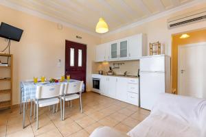 PóndiにあるVilla Captain Fotis 2の白いキャビネットとテーブルと椅子のあるキッチン