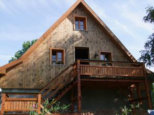 a large wooden house with a deck at Ferienwohnung Vogelsang in Neuburg