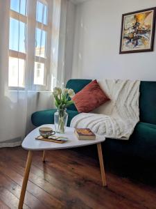 a living room with a green couch and a table at Honey I`m home Apartments in Veliko Tŭrnovo