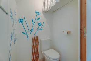 a bathroom with a toilet with blue flowers on the wall at Maison proche Mont St Michel in Pontorson +18 photos