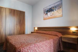 a bedroom with a bed and a wooden headboard at Residence Paradiso Bilocale 303 in Moneglia