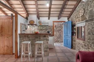 コニル・デ・ラ・フロンテーラにあるCasas Alfonso y Lauraの青いドアとスツール付きのキッチン