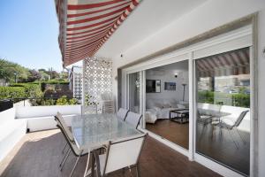 a living room with a glass table and a couch at Primera línea con vistas al mar in El Puerto de Santa María