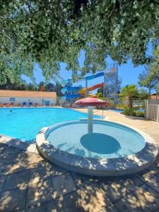 einen Pool mit Sonnenschirm und Pool in der Unterkunft Mobil Home sur camping avec piscine in Saint-Jean-de-Monts
