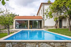 una piscina en el patio trasero de una casa con casa en Casa do Mestre Studio e Suíte Extra, en Vila de Punhe