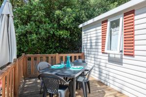 einen Tisch und Stühle auf der Terrasse eines Hauses in der Unterkunft Mobil Home sur camping avec piscine in Saint-Jean-de-Monts
