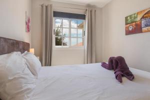 a white bed with a stuffed animal on top of it at Caleta Beach Deluxe in Caleta De Fuste +12 photos