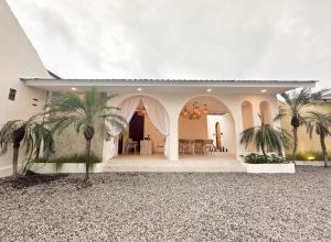 a white house with palm trees in front of it at Canggu Villas Family Yogyakarta in Ngaglik