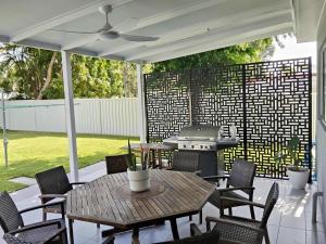 a patio with a table and chairs and a grill at Carefree Comfort in Deception Bay