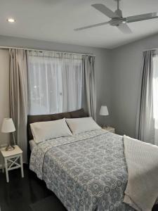 Deception BayにあるCarefree Comfortのベッドと天井扇風機のある寝室
