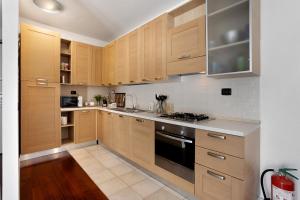 a kitchen with wooden cabinets and a stove top oven at vb home brianza in Costa Masnaga