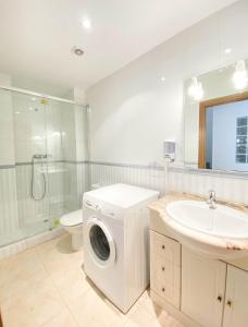 a bathroom with a washing machine and a sink at Constance in L'Ampolla