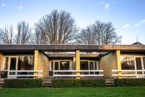 a large brick building with trees in the background at Fuglsang Have B&B 