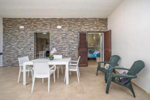 a dining room with a white table and chairs at Azure Bay Luxury Villa in Torre Squillace