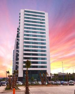 wysoki budynek z zachodem słońca przed nim w obiekcie Mogador Marina w mieście Casablanca