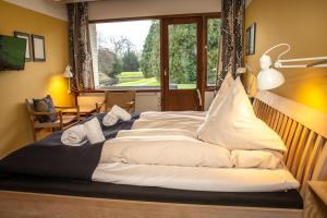 a large bed in a room with a large window at Fuglsang Have B&B 