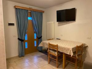 een eetkamer met een tafel met stoelen en een televisie bij Appartamento Piz Orsera in Livigno