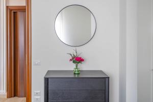 a vase of flowers on a dresser with a mirror at Matera Castle Suite in Matera +23 photos