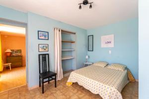 une chambre avec un lit et une chaise dans l'établissement Escale des Crozes, à Saint-Romain-en-Viennois 23 autres photos