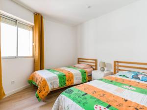 Dos camas individuales en una habitación con ventana. en Casa Musica, en Corralejo