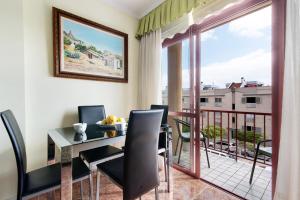 a dining room with a table and chairs and a balcony at Mar y Sol Salinetas in Telde