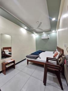 a room with a bed and a table and a mirror at TARA Guest House in Ujjain