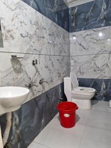 a bathroom with a toilet and a sink at TARA Guest House in Ujjain +55 photos