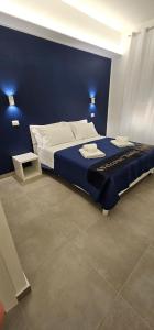 um quarto com uma cama com uma parede azul em b&b il gioiello em Reggio di Calabria