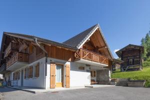 a house with a gambrel roof with a balcony at Les Salamanes - Chalet 6-7 pers in Sixt