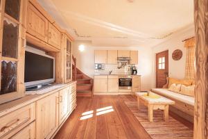 a living room with a couch and a television in a room at Kofler zw den Wänden Apt Himmelschlüssel in Campo Tures