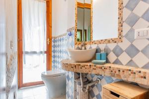 un baño con lavabo y espejo en Villa Alice, en Villasimius