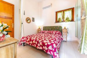 Un dormitorio con una cama roja y una ventana. en Villa Alice, en Villasimius
