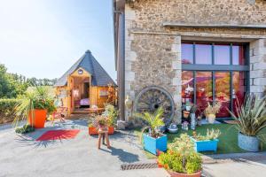 une maison avec des plantes en pot devant dans l'établissement Les Philous Gourmands, à Sevremont