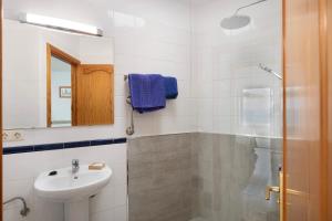 Un baño blanco con lavabo y ducha. en Callao Beach 8, en Arrieta 22 fotos más