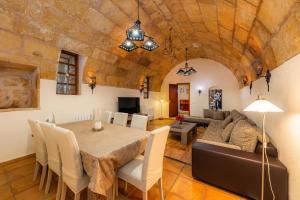 a dining room with a table and a couch at Finca Son Favar Capdepera in Capdepera