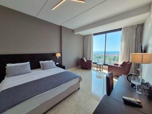 ジュベイルにある365 UrbanLivingの大きなベッドと机があるホテルの部屋