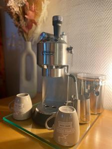 une cafetière assise sur un comptoir avec deux tasses dans l'établissement Das CLASSIQUE Galerieappartement - Wohlfühlen auf zwei Etagen, TV, ruhiger Balkon, Poseidon Therme im Haus, sowieso Kinder und Vierbeinerfreunde willkommen, inkl Parkgarage u Kurtaxe, à Bad Griesbach im Rottal