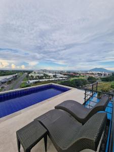 a balcony with two chairs and a swimming pool at A cozy and spacious Studio apartment Angeles city pampanga in Angeles