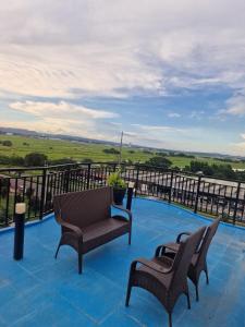 two chairs and a couch on a balcony with a view at A cozy and spacious Studio apartment Angeles city pampanga in Angeles +5 photos