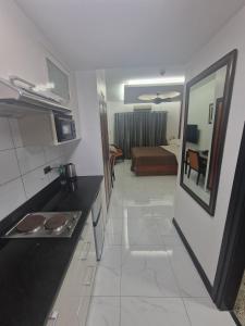 a kitchen with a sink and a room with a bed at A cozy and spacious Studio apartment Angeles city pampanga in Angeles