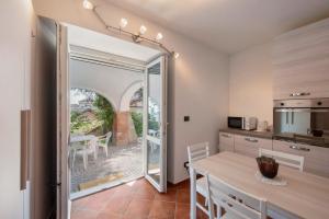 a kitchen and dining room with a table and a balcony at Vacanza Nel Cuore Del Monferrato in Rocca Grimalda