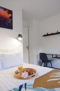a tray with a drink and a plate of food on a bed at Le Sully Terrasse - Parking privé - 5min Gare RER in Evry-Courcouronnes