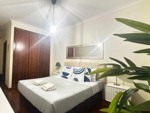a bedroom with a bed and a potted plant at To Be Apartments in Bobadela