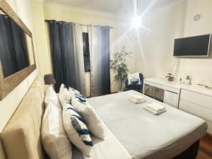 a room with a couch and a desk and a tv at To Be Apartments in Bobadela