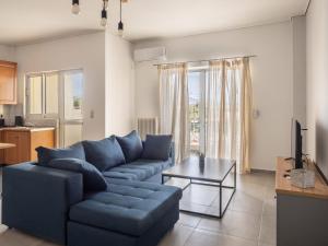 スパタにあるSunrise By Athens Airportの青いソファとテーブルのあるリビングルーム