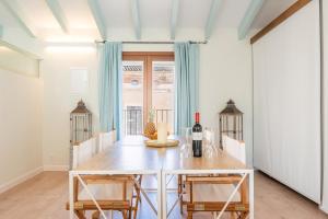 een eetkamer met een tafel met een fles wijn bij Can 32 Apartamento 2 habitaciones in Pollença
