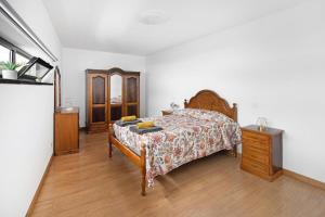 a bedroom with a bed and a wooden dresser at Casa Caminho da Esperança in Porto Judeu