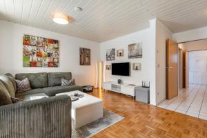 un salon avec un canapé et une télévision dans l'établissement Fewo mit Terrasse - Hunde erwünscht, à Falkenstein